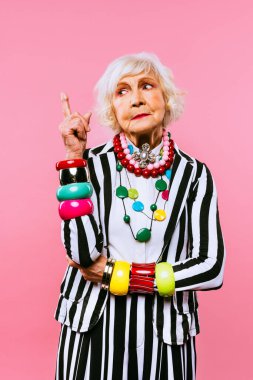 Renkli arka planda modaya uygun kıyafet portresi olan mutlu ve komik yaşlı kadın - abartılı tarzı olan genç büyükanne, yaşam tarzı, kıdemli ve yaşlı insanlar hakkında kavramlar