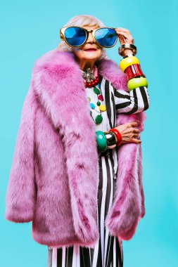 Renkli arka planda modaya uygun kıyafet portresi olan mutlu ve komik yaşlı kadın - abartılı tarzı olan genç büyükanne, yaşam tarzı, kıdemli ve yaşlı insanlar hakkında kavramlar