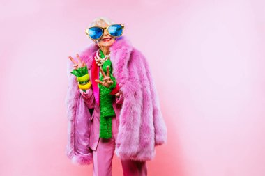 Renkli arka planda modaya uygun kıyafet portresi olan mutlu ve komik yaşlı kadın - abartılı tarzı olan genç büyükanne, yaşam tarzı, kıdemli ve yaşlı insanlar hakkında kavramlar