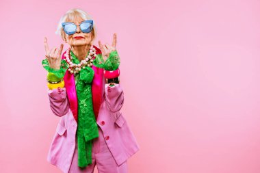 Renkli arka planda modaya uygun kıyafet portresi olan mutlu ve komik yaşlı kadın - abartılı tarzı olan genç büyükanne, yaşam tarzı, kıdemli ve yaşlı insanlar hakkında kavramlar