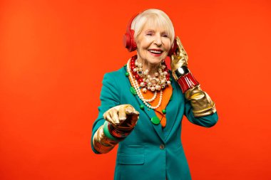 Renkli arka planda modaya uygun kıyafet portresi olan mutlu ve komik yaşlı kadın - abartılı tarzı olan genç büyükanne, yaşam tarzı, kıdemli ve yaşlı insanlar hakkında kavramlar