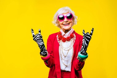 Renkli arka planda modaya uygun kıyafet portresi olan mutlu ve komik yaşlı kadın - abartılı tarzı olan genç büyükanne, yaşam tarzı, kıdemli ve yaşlı insanlar hakkında kavramlar