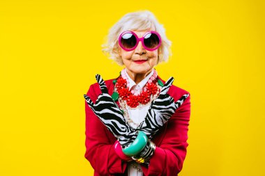 Renkli arka planda modaya uygun kıyafet portresi olan mutlu ve komik yaşlı kadın - abartılı tarzı olan genç büyükanne, yaşam tarzı, kıdemli ve yaşlı insanlar hakkında kavramlar