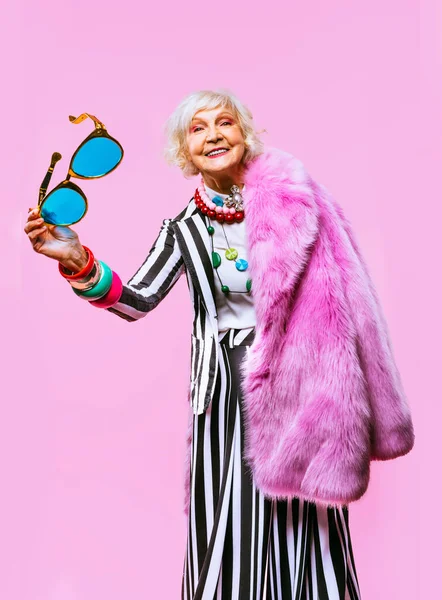 Happy and funny cool old lady with fashionable clothes portrait on colored background - Youthful grandmother with extravagant style, concepts about lifestyle, seniority and elderly people