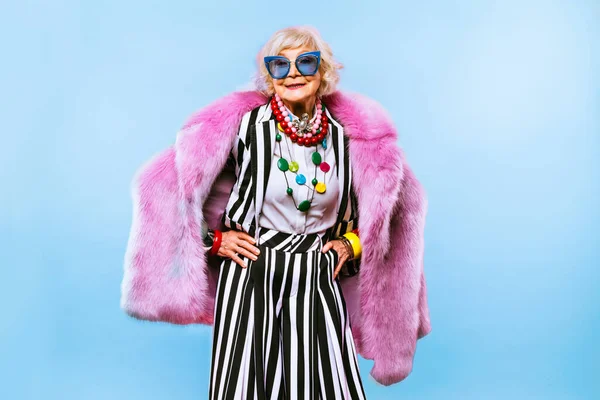 Happy and funny cool old lady with fashionable clothes portrait on colored background - Youthful grandmother with extravagant style, concepts about lifestyle, seniority and elderly people