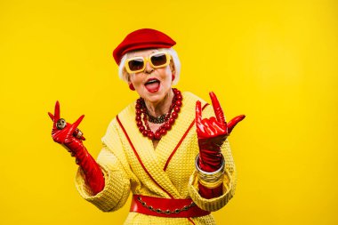 Renkli arka planda modaya uygun kıyafet portresi olan mutlu ve komik yaşlı kadın - abartılı tarzı olan genç büyükanne, yaşam tarzı, kıdemli ve yaşlı insanlar hakkında kavramlar