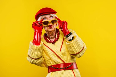 Renkli arka planda modaya uygun kıyafet portresi olan mutlu ve komik yaşlı kadın - abartılı tarzı olan genç büyükanne, yaşam tarzı, kıdemli ve yaşlı insanlar hakkında kavramlar