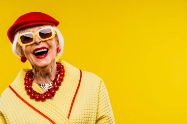 Renkli arka planda modaya uygun kıyafet portresi olan mutlu ve komik yaşlı kadın - abartılı tarzı olan genç büyükanne, yaşam tarzı, kıdemli ve yaşlı insanlar hakkında kavramlar