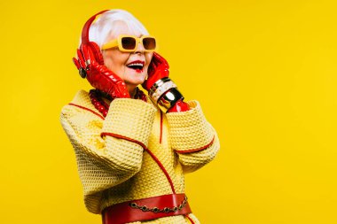 Renkli arka planda modaya uygun kıyafet portresi olan mutlu ve komik yaşlı kadın - abartılı tarzı olan genç büyükanne, yaşam tarzı, kıdemli ve yaşlı insanlar hakkında kavramlar