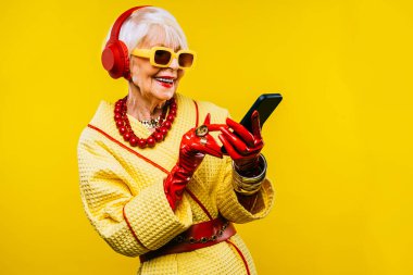 Renkli arka planda modaya uygun kıyafet portresi olan mutlu ve komik yaşlı kadın - abartılı tarzı olan genç büyükanne, yaşam tarzı, kıdemli ve yaşlı insanlar hakkında kavramlar