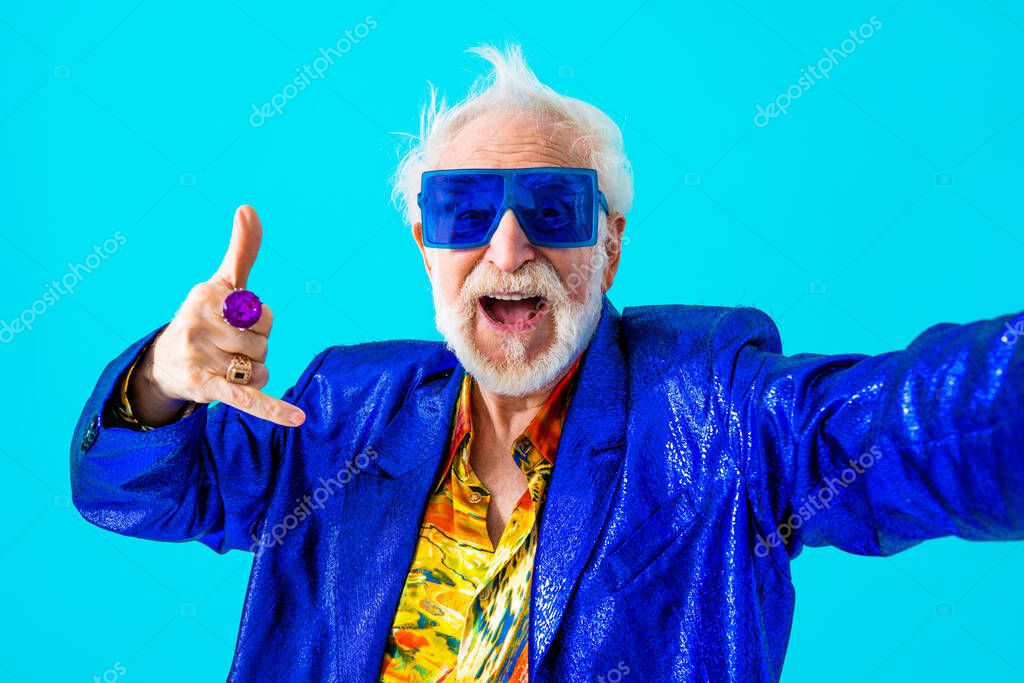 Cool senior man with fashionable clothing style portrait on colored background - Funny old male pensioner with eccentric style having fun