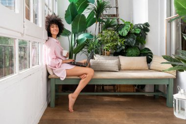 Evdeki güzel Latin kadın güzel, kıvırcık saçlı, hayat tarzı ve aile hayatı olan Güney Amerikalı.