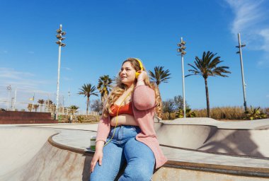 Güzel ve neşeli genç bir kadın, açık havada oldukça kilolu, kıvrımlı bir kadın, kadınlık kavramları, kadın gücü, kadın özgürlüğü, vücut pozitifliği ve vücut kabulü.