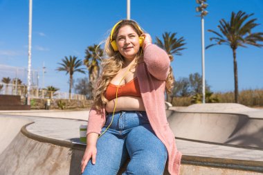 Güzel ve neşeli genç bir kadın, açık havada oldukça kilolu, kıvrımlı bir kadın, kadınlık kavramları, kadın gücü, kadın özgürlüğü, vücut pozitifliği ve vücut kabulü.