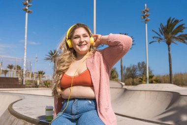 Güzel ve neşeli genç bir kadın, açık havada oldukça kilolu, kıvrımlı bir kadın, kadınlık kavramları, kadın gücü, kadın özgürlüğü, vücut pozitifliği ve vücut kabulü.