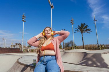 Güzel ve neşeli genç bir kadın, açık havada oldukça kilolu, kıvrımlı bir kadın, kadınlık kavramları, kadın gücü, kadın özgürlüğü, vücut pozitifliği ve vücut kabulü.