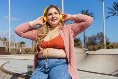 Güzel ve neşeli genç bir kadın, açık havada oldukça kilolu, kıvrımlı bir kadın, kadınlık kavramları, kadın gücü, kadın özgürlüğü, vücut pozitifliği ve vücut kabulü.