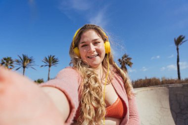 Güzel ve neşeli genç bir kadın, açık havada oldukça kilolu, kıvrımlı bir kadın, kadınlık kavramları, kadın gücü, kadın özgürlüğü, vücut pozitifliği ve vücut kabulü.