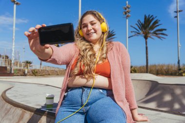 Güzel ve neşeli genç bir kadın, açık havada oldukça kilolu, kıvrımlı bir kadın, kadınlık kavramları, kadın gücü, kadın özgürlüğü, vücut pozitifliği ve vücut kabulü.