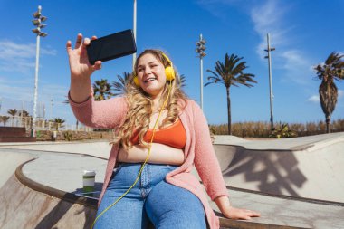 Güzel ve neşeli genç bir kadın, açık havada oldukça kilolu, kıvrımlı bir kadın, kadınlık kavramları, kadın gücü, kadın özgürlüğü, vücut pozitifliği ve vücut kabulü.