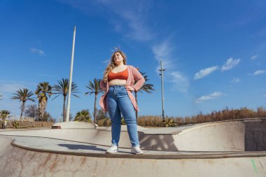 Güzel ve neşeli genç bir kadın, açık havada oldukça kilolu, kıvrımlı bir kadın, kadınlık kavramları, kadın gücü, kadın özgürlüğü, vücut pozitifliği ve vücut kabulü.