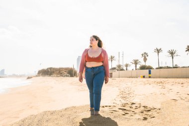 Güzel ve neşeli genç bir kadın, açık havada oldukça kilolu, kıvrımlı bir kadın, kadınlık kavramları, kadın gücü, kadın özgürlüğü, vücut pozitifliği ve vücut kabulü.