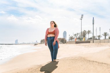 Güzel ve neşeli genç bir kadın, açık havada oldukça kilolu, kıvrımlı bir kadın, kadınlık kavramları, kadın gücü, kadın özgürlüğü, vücut pozitifliği ve vücut kabulü.