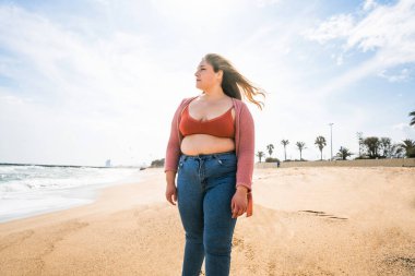 Güzel ve neşeli genç bir kadın, açık havada oldukça kilolu, kıvrımlı bir kadın, kadınlık kavramları, kadın gücü, kadın özgürlüğü, vücut pozitifliği ve vücut kabulü.