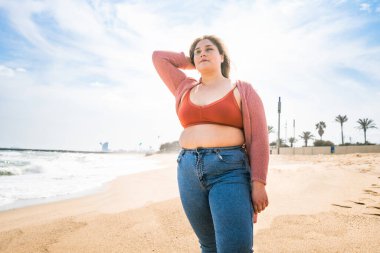 Güzel ve neşeli genç bir kadın, açık havada oldukça kilolu, kıvrımlı bir kadın, kadınlık kavramları, kadın gücü, kadın özgürlüğü, vücut pozitifliği ve vücut kabulü.