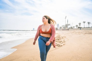 Güzel ve neşeli genç bir kadın, açık havada oldukça kilolu, kıvrımlı bir kadın, kadınlık kavramları, kadın gücü, kadın özgürlüğü, vücut pozitifliği ve vücut kabulü.