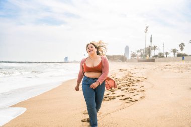 Güzel ve neşeli genç bir kadın, açık havada oldukça kilolu, kıvrımlı bir kadın, kadınlık kavramları, kadın gücü, kadın özgürlüğü, vücut pozitifliği ve vücut kabulü.