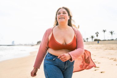 Güzel ve neşeli genç bir kadın, açık havada oldukça kilolu, kıvrımlı bir kadın, kadınlık kavramları, kadın gücü, kadın özgürlüğü, vücut pozitifliği ve vücut kabulü.