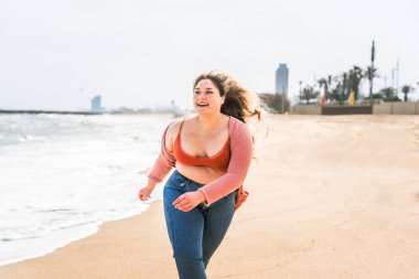 Güzel ve neşeli genç bir kadın, açık havada oldukça kilolu, kıvrımlı bir kadın, kadınlık kavramları, kadın gücü, kadın özgürlüğü, vücut pozitifliği ve vücut kabulü.