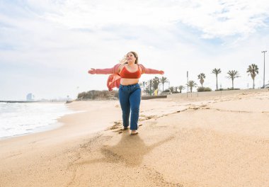 Güzel ve neşeli genç bir kadın, açık havada oldukça kilolu, kıvrımlı bir kadın, kadınlık kavramları, kadın gücü, kadın özgürlüğü, vücut pozitifliği ve vücut kabulü.