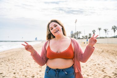 Güzel ve neşeli genç bir kadın, açık havada oldukça kilolu, kıvrımlı bir kadın, kadınlık kavramları, kadın gücü, kadın özgürlüğü, vücut pozitifliği ve vücut kabulü.