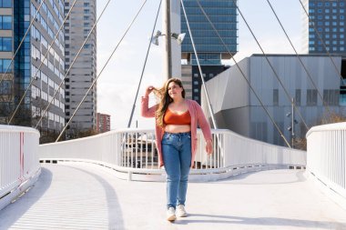 Güzel ve neşeli genç bir kadın, açık havada oldukça kilolu, kıvrımlı bir kadın, kadınlık kavramları, kadın gücü, kadın özgürlüğü, vücut pozitifliği ve vücut kabulü.