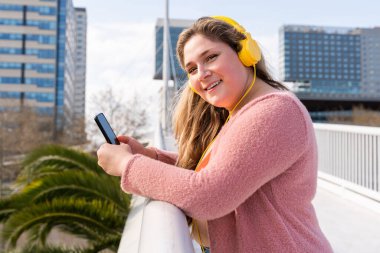 Güzel ve neşeli genç bir kadın, açık havada oldukça kilolu, kıvrımlı bir kadın, kadınlık kavramları, kadın gücü, kadın özgürlüğü, vücut pozitifliği ve vücut kabulü.