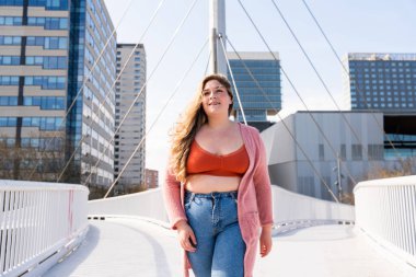 Güzel ve neşeli genç bir kadın, açık havada oldukça kilolu, kıvrımlı bir kadın, kadınlık kavramları, kadın gücü, kadın özgürlüğü, vücut pozitifliği ve vücut kabulü.