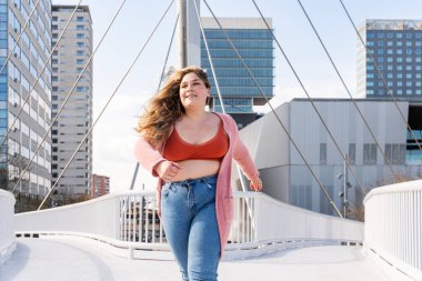 Güzel ve neşeli genç bir kadın, açık havada oldukça kilolu, kıvrımlı bir kadın, kadınlık kavramları, kadın gücü, kadın özgürlüğü, vücut pozitifliği ve vücut kabulü.