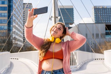Güzel ve neşeli genç bir kadın, açık havada oldukça kilolu, kıvrımlı bir kadın, kadınlık kavramları, kadın gücü, kadın özgürlüğü, vücut pozitifliği ve vücut kabulü.