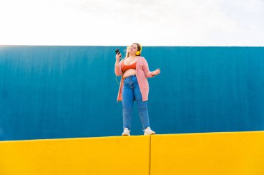 Beautiful and cheerful plus size young woman outdoors - Pretty overweight curvy female, concepts about femininity, women power, female emancipation, body positivity and body acceptance