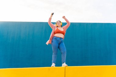Beautiful and cheerful plus size young woman outdoors - Pretty overweight curvy female, concepts about femininity, women power, female emancipation, body positivity and body acceptance
