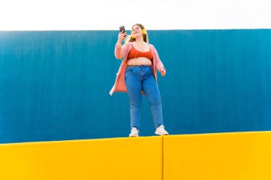 Beautiful and cheerful plus size young woman outdoors - Pretty overweight curvy female, concepts about femininity, women power, female emancipation, body positivity and body acceptance