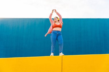Beautiful and cheerful plus size young woman outdoors - Pretty overweight curvy female, concepts about femininity, women power, female emancipation, body positivity and body acceptance
