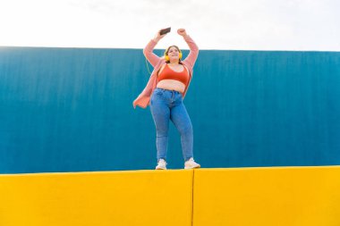 Beautiful and cheerful plus size young woman outdoors - Pretty overweight curvy female, concepts about femininity, women power, female emancipation, body positivity and body acceptance