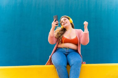 Güzel ve neşeli genç bir kadın, açık havada oldukça kilolu, kıvrımlı bir kadın, kadınlık kavramları, kadın gücü, kadın özgürlüğü, vücut pozitifliği ve vücut kabulü.