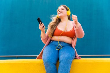 Güzel ve neşeli genç bir kadın, açık havada oldukça kilolu, kıvrımlı bir kadın, kadınlık kavramları, kadın gücü, kadın özgürlüğü, vücut pozitifliği ve vücut kabulü.