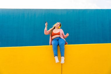 Beautiful and cheerful plus size young woman outdoors - Pretty overweight curvy female, concepts about femininity, women power, female emancipation, body positivity and body acceptance