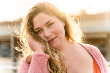 Güzel ve neşeli genç bir kadın, açık havada oldukça kilolu, kıvrımlı bir kadın, kadınlık kavramları, kadın gücü, kadın özgürlüğü, vücut pozitifliği ve vücut kabulü.