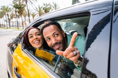 Güzel, mutlu Latin aşıklar Barselona 'da turistler yaz tatilinde eğleniyor ve taksiye biniyor.